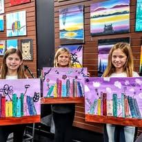 Customers Holding Bookshelf Paint Canvas At Cheers N Paint Art Studio In Cary, Nc