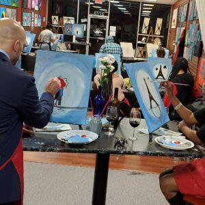 A couple painting a portrait at Valentine's Paint and Sip class in Cary, NC at Cheers N Paint art studio.