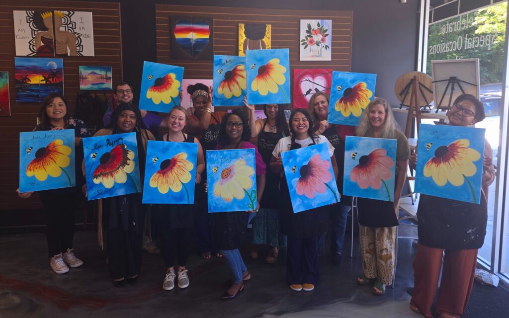 Corporate Team Building Event At Cheers N Paint, Team Members Holding Art With Flowers.