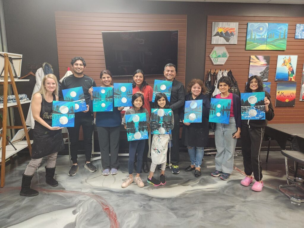 family after art class holding moon paintings in Cary NC