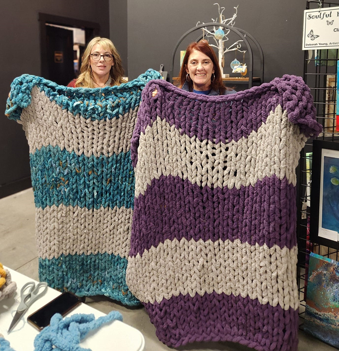 Women holding Chunky Knitted Blanket after Chunky Knit Blanket Class in Cary NC with Cheers N Paint