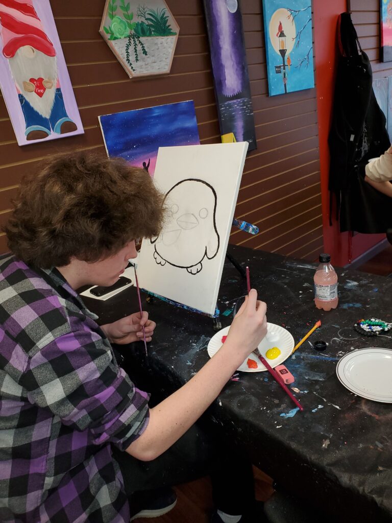 teen boy painting at art class in Cary, NC at Cheers N Paint Studio